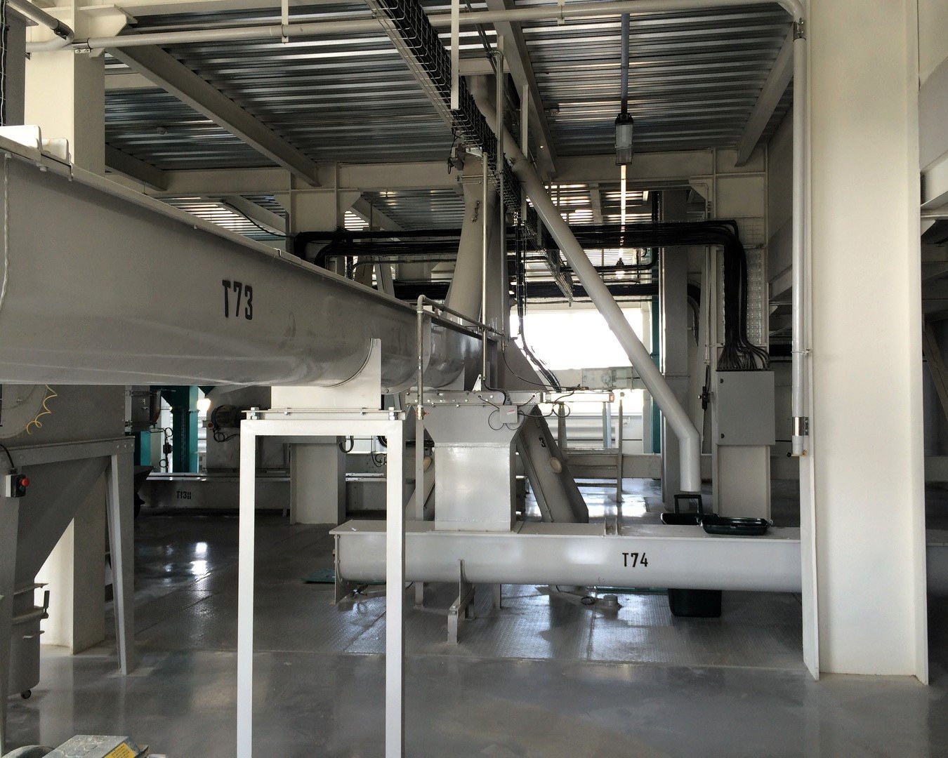 Transgravity blade conveyor in a feed mill