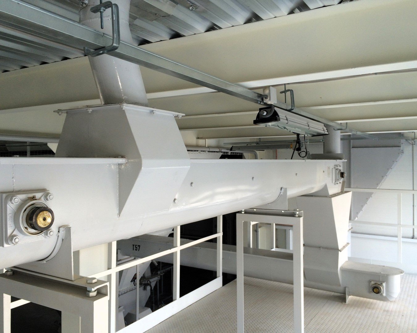 Transgravity blade conveyor in a feed mill