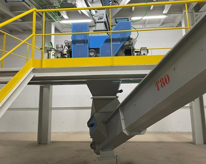 Transgravity blade conveyor in a feed mill