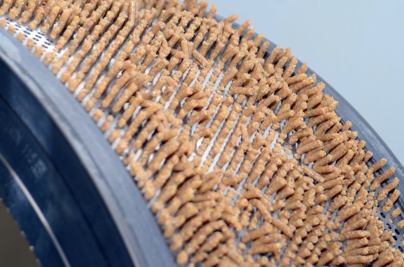 Matriz con alimento para animales saliendo por los orificios.